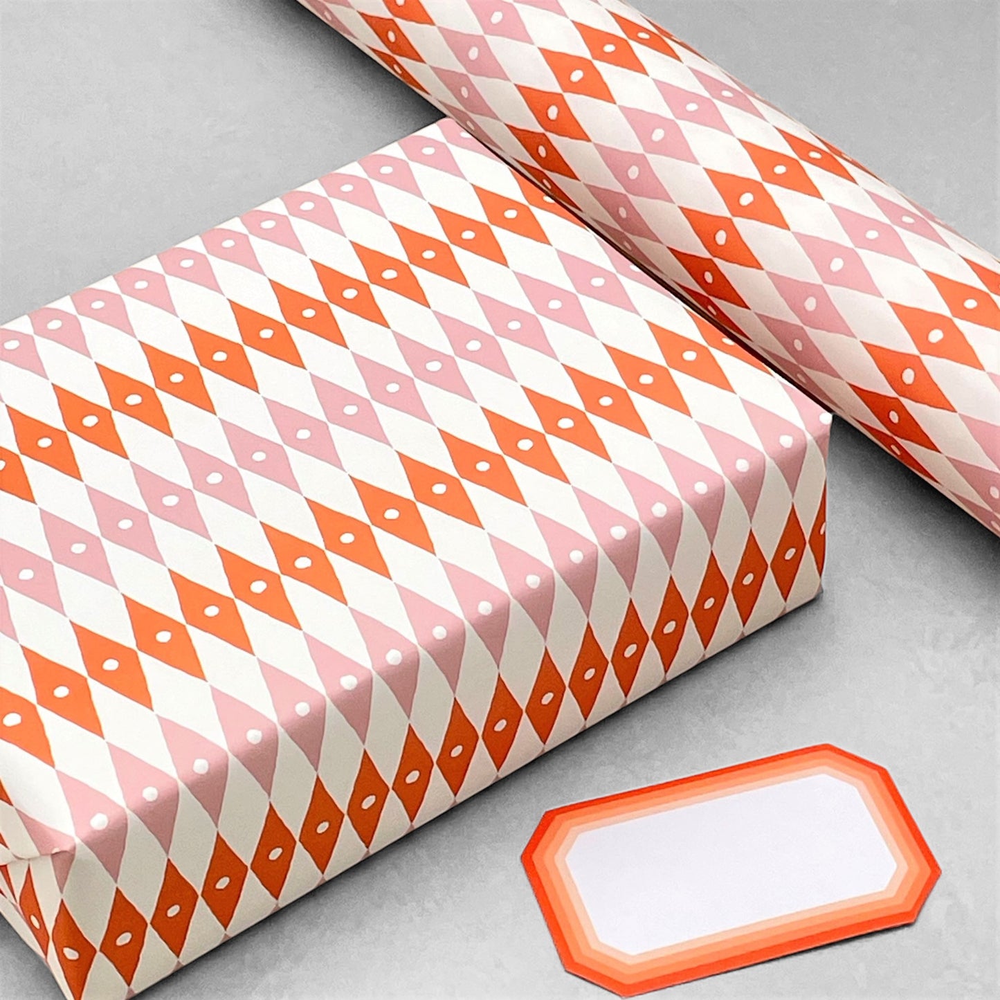harlequin diamond design patterned paper gift wrap in pink and orange, by Ariana Martin