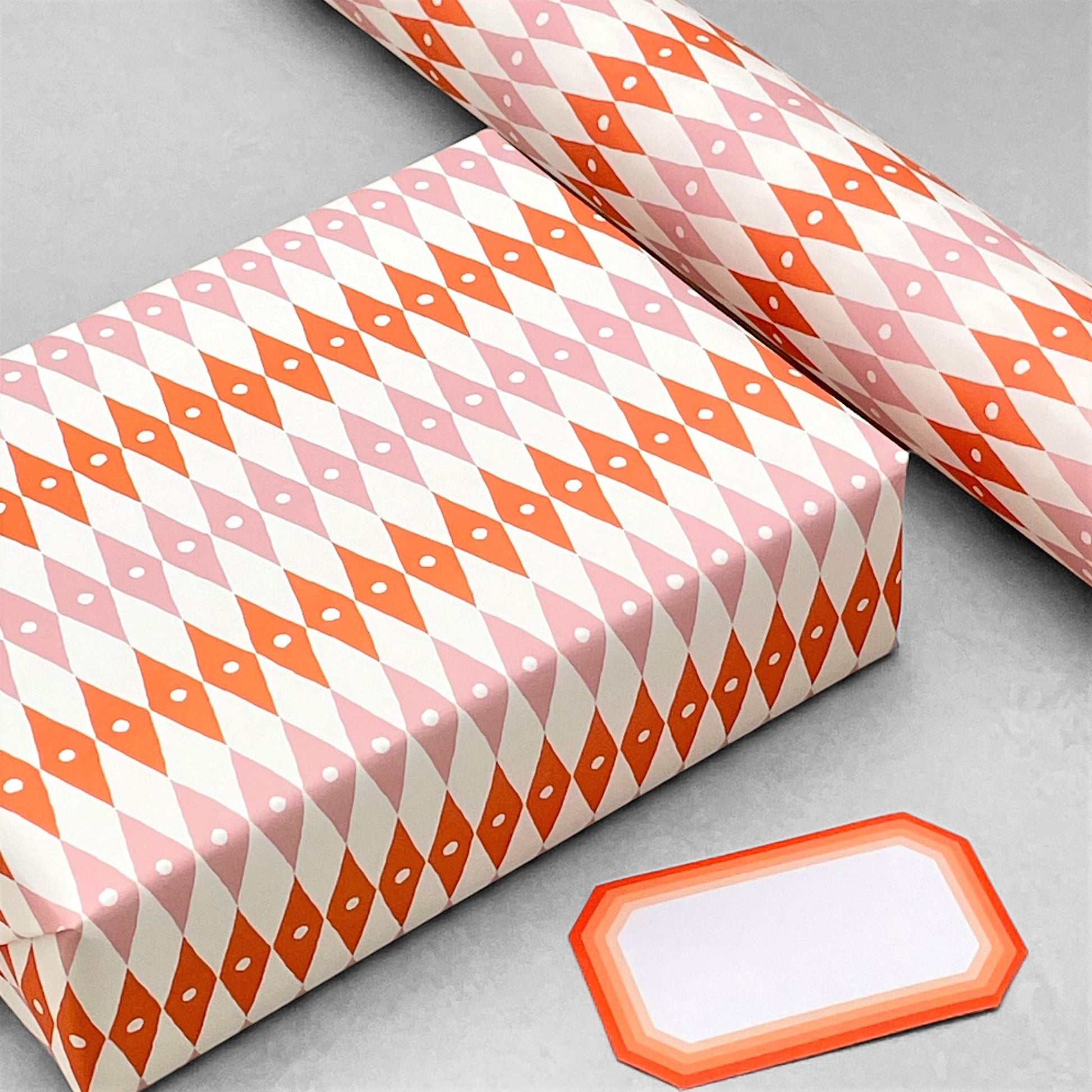 harlequin diamond design patterned paper gift wrap in pink and orange, by Ariana Martin