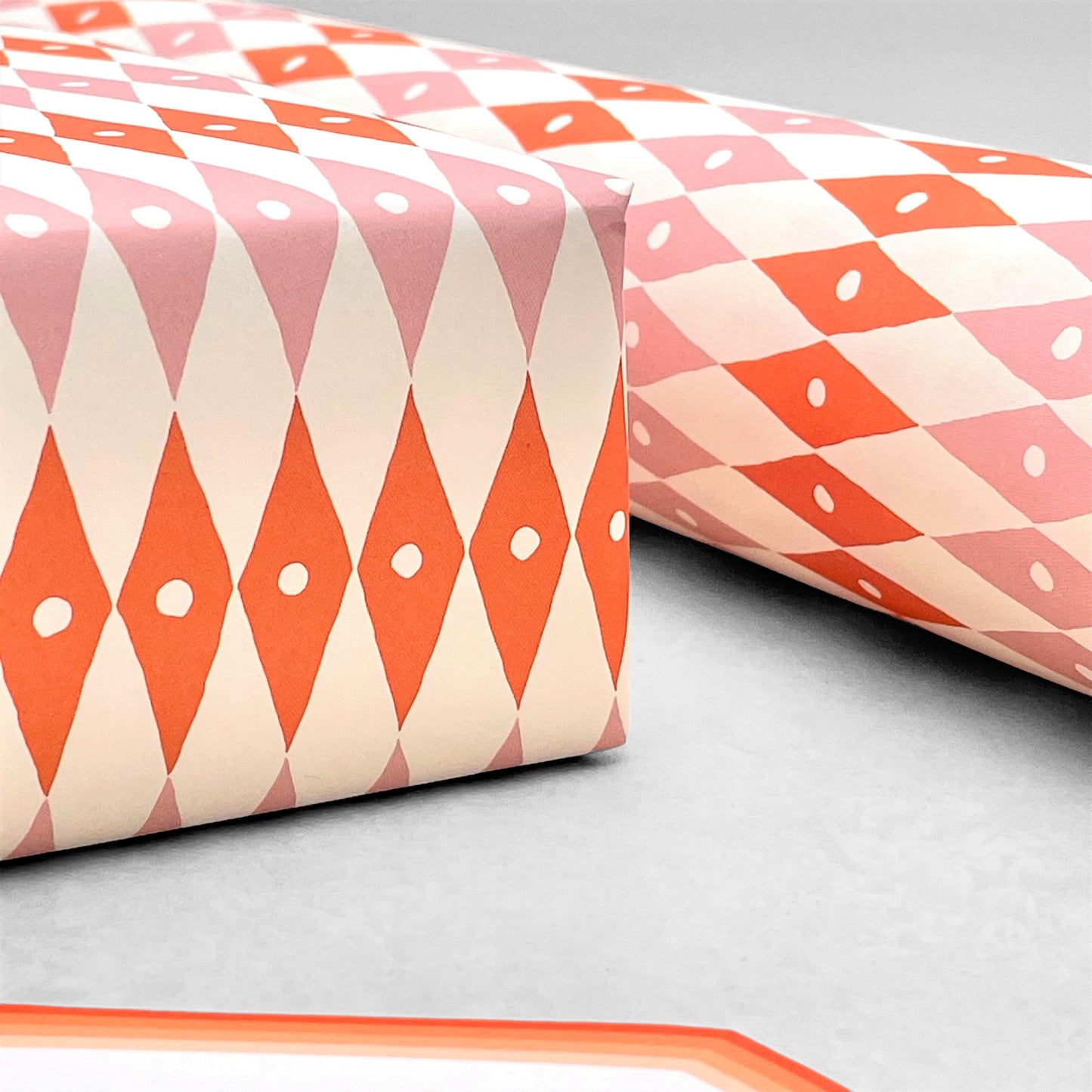 harlequin diamond design patterned paper gift wrap in pink and orange, by Ariana Martin