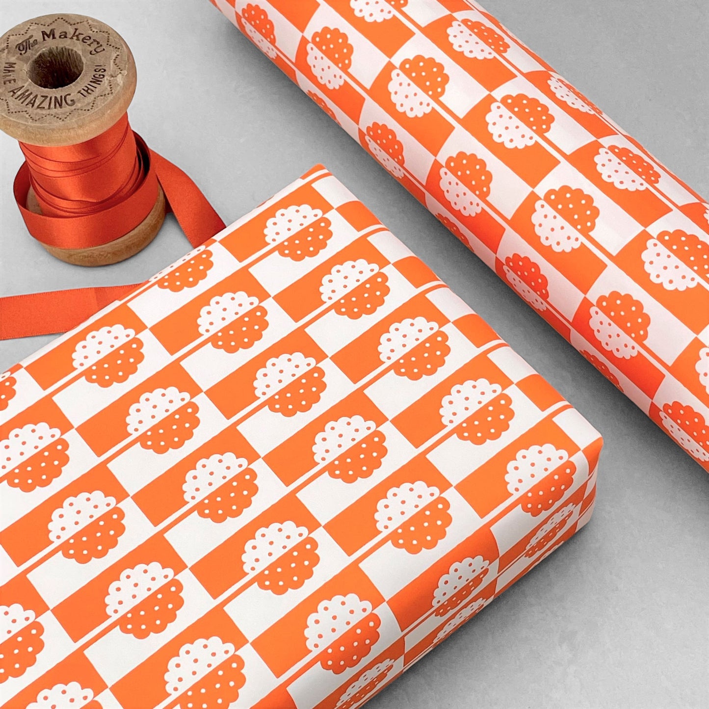 patterned paper, gift wrap, with all-over holly tree design in bright orange and white, by Ariana Martin