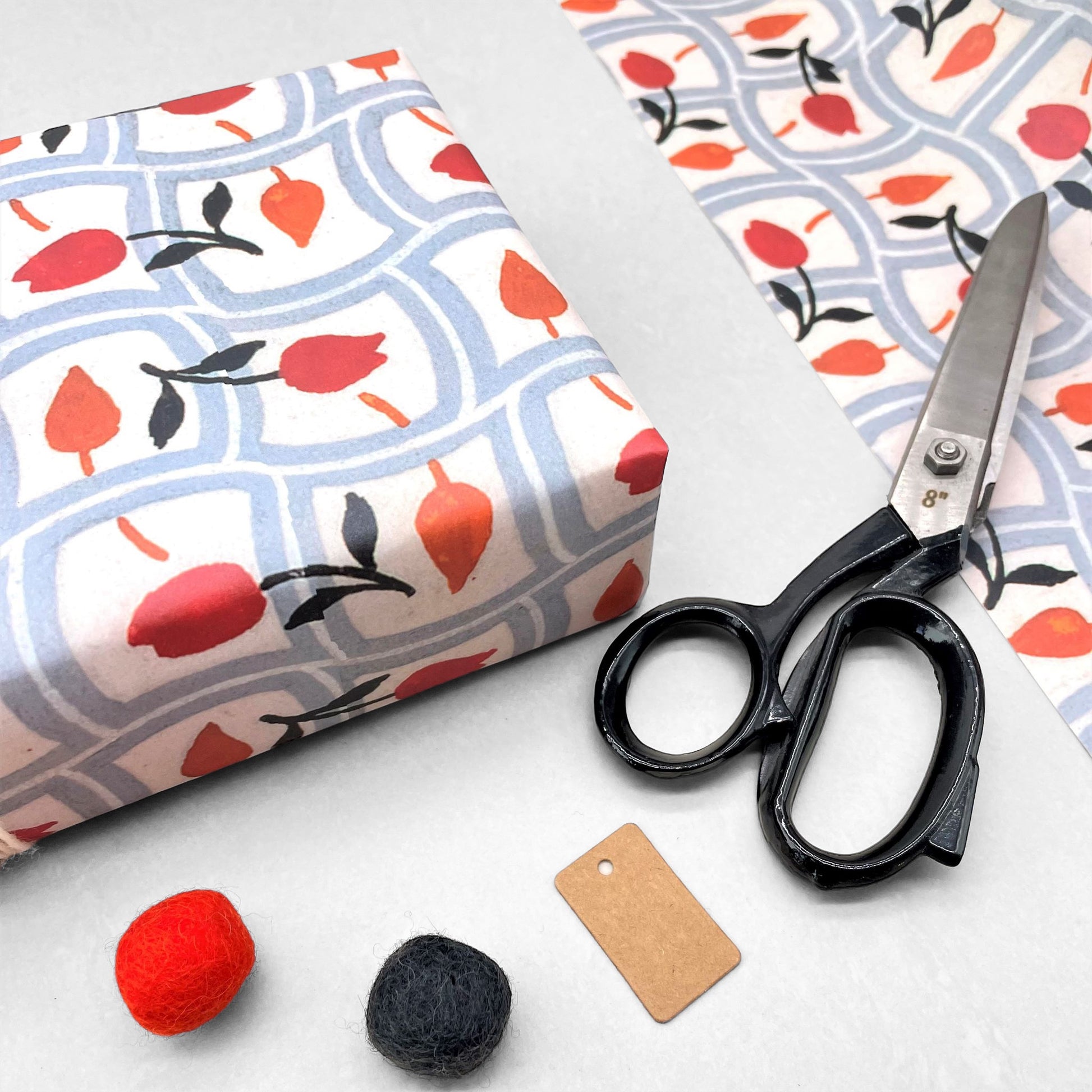 wrapping paper with repeat pattern on red tulips on a duck egg wavy grid backdrop by Artisan Deesign. Design Silver Studio