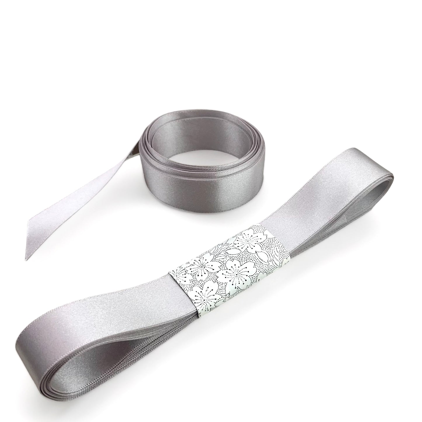 Satin ribbon 25mm wide and 5 metres long, presented with a patterned paper band. colour - silver grey