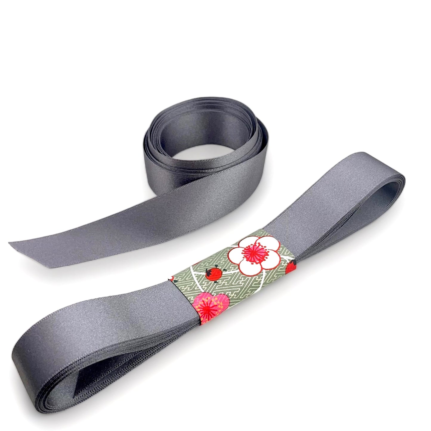 Satin ribbon 25mm wide and 5 metres long, presented with a patterned paper band. colour - smoked grey