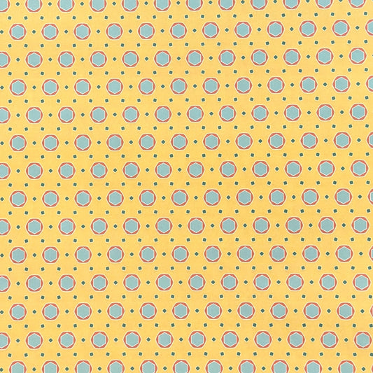 a sheet of wrapping paper with a yellow background and colorful blue circles pattern