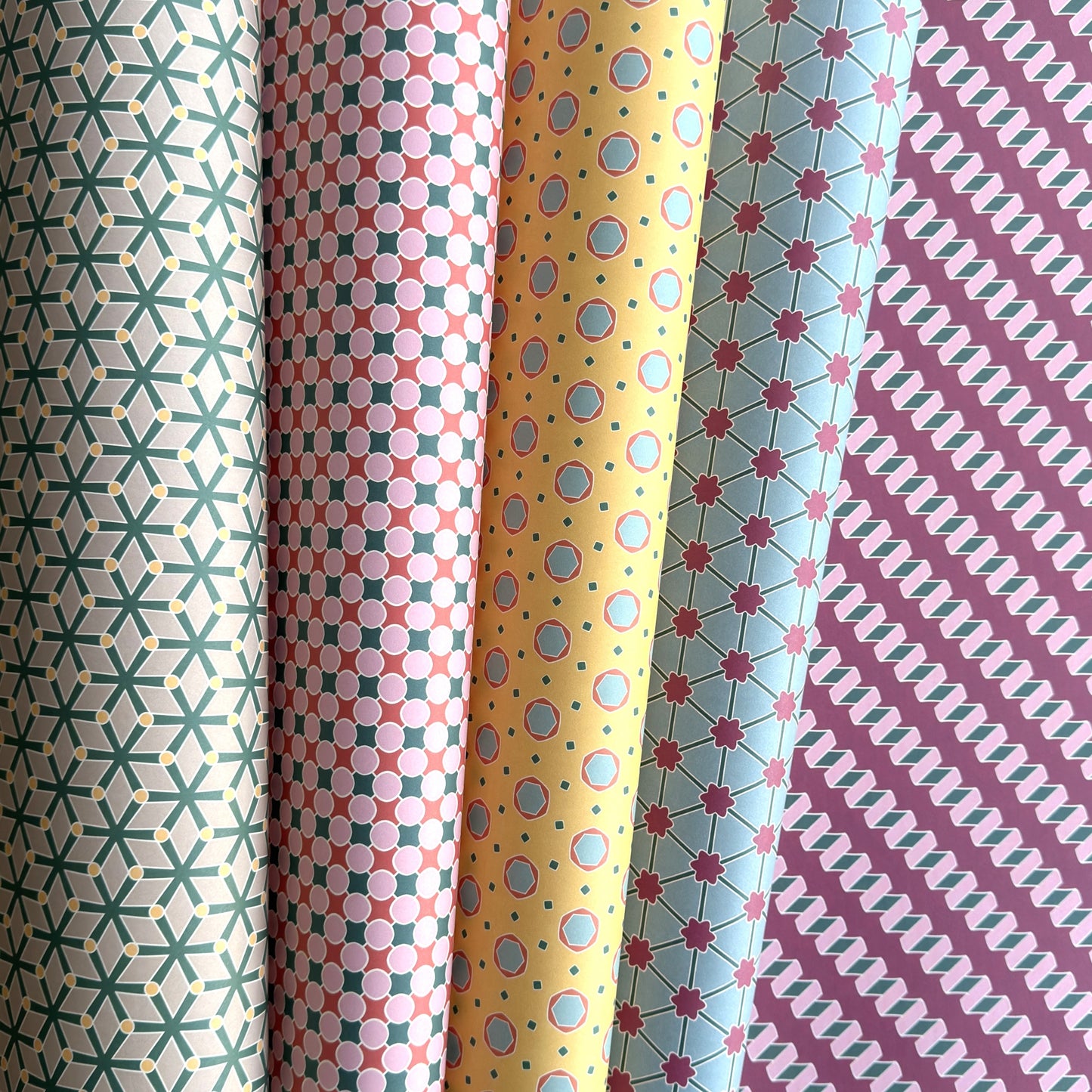 Collection of patterned paper rolls with geometric designs.