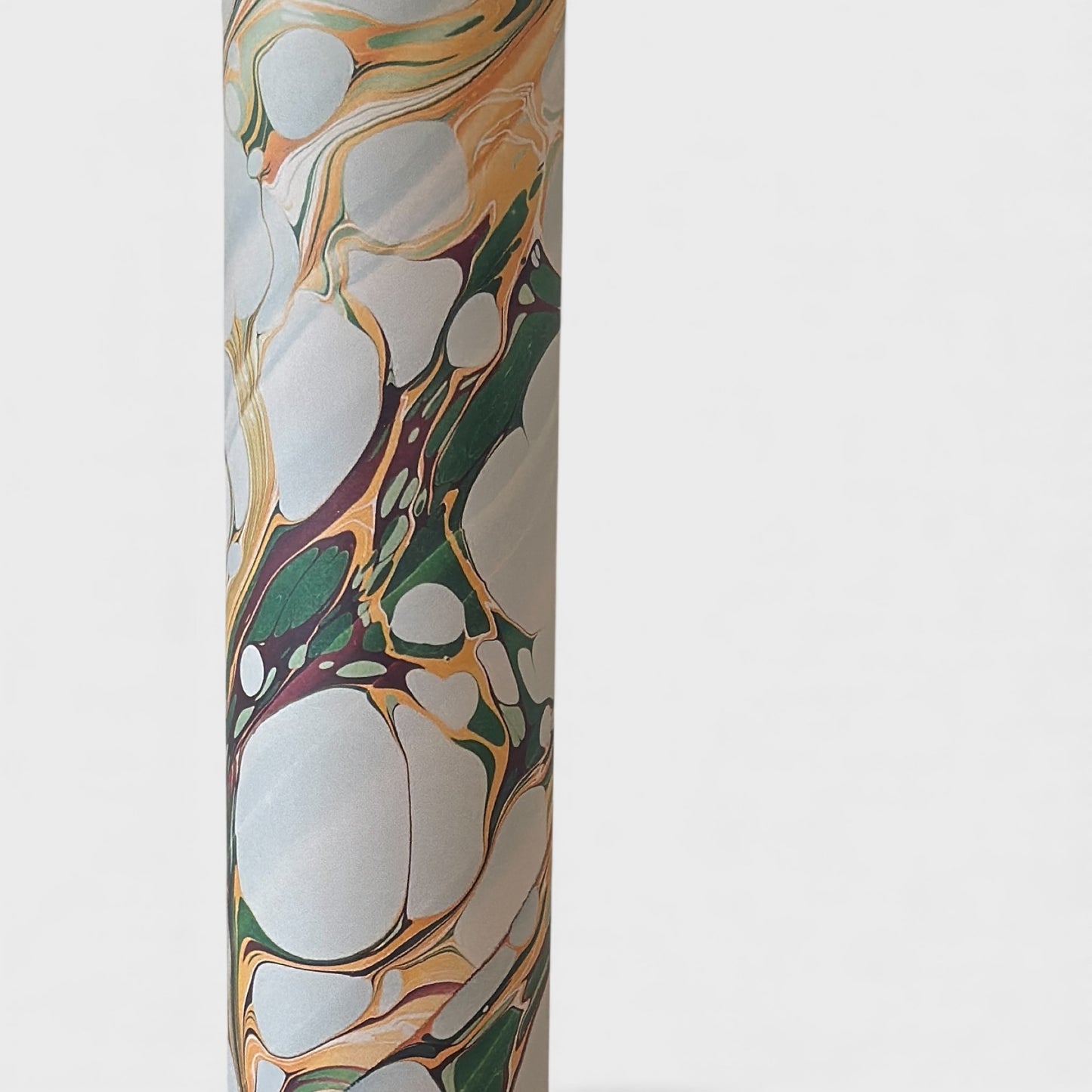 Printed marbled gift wrapping paper by Compton Marbling with a stone marbling pattern in soft grey, green and mustard. Close up