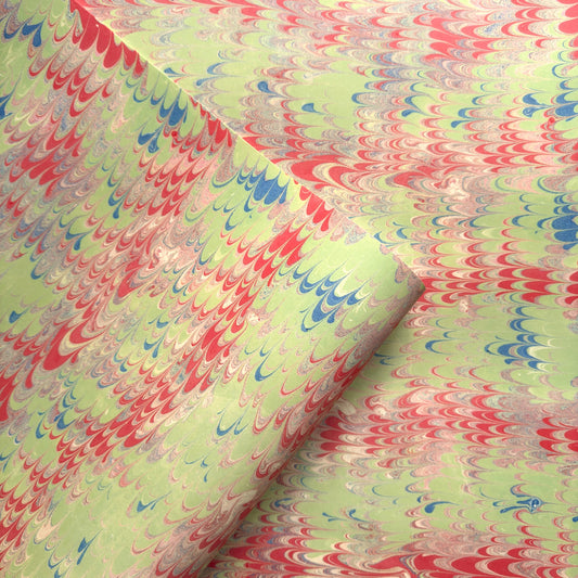 a sheet of wrapping paper with a marbled design in lime green, red and blue
