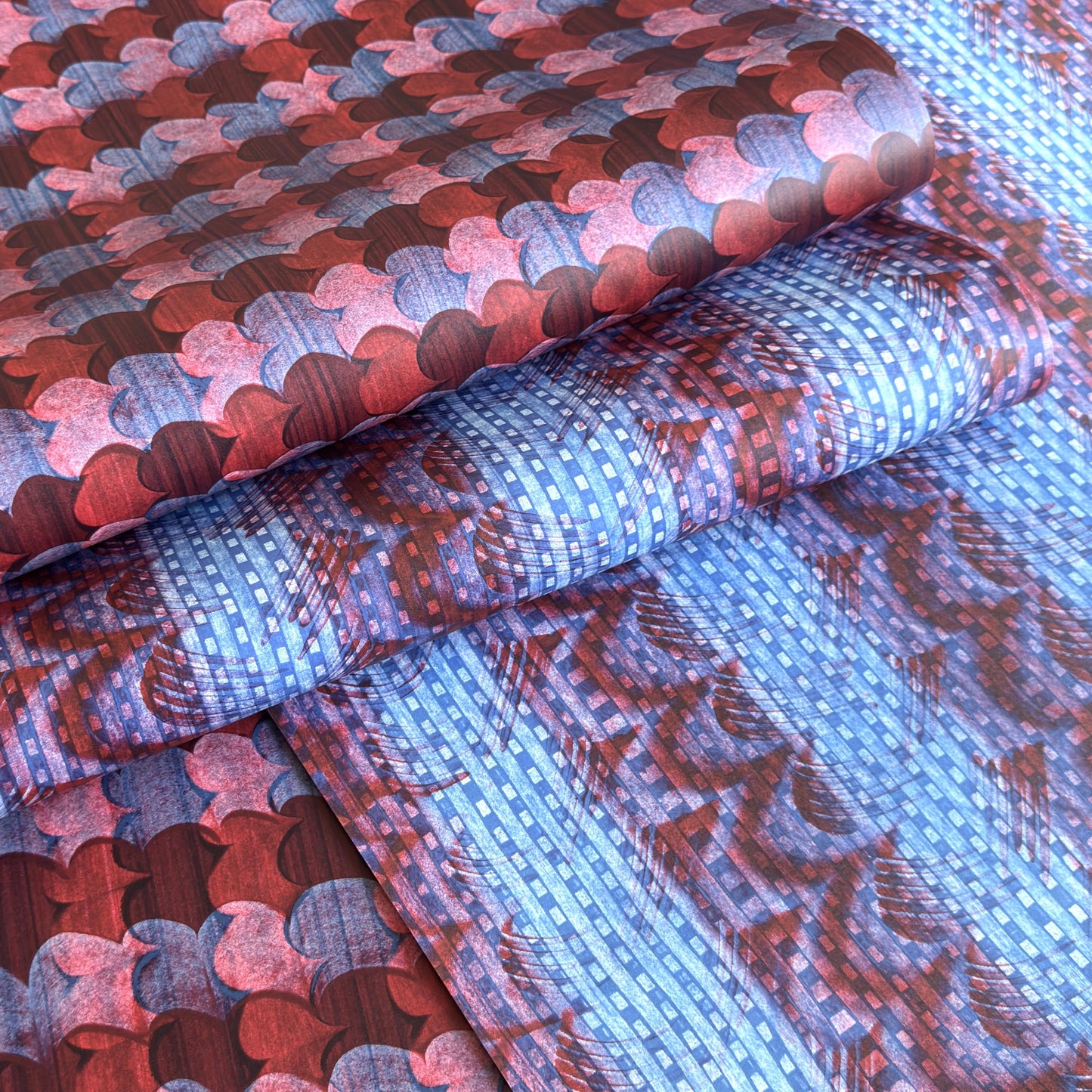 a sheet of wrapping paper with a paste paper style design in blue and dark red