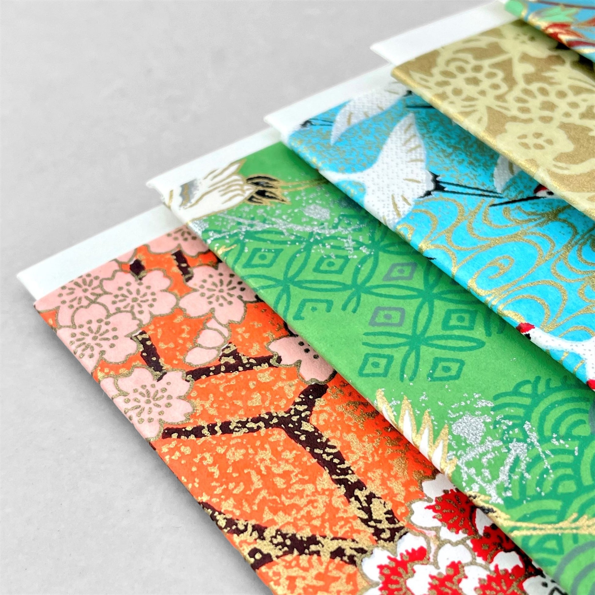 japanese silk-screen printed greetings card with a pattern of peach, white and red blossom branches on an orange backdrop by Esmie