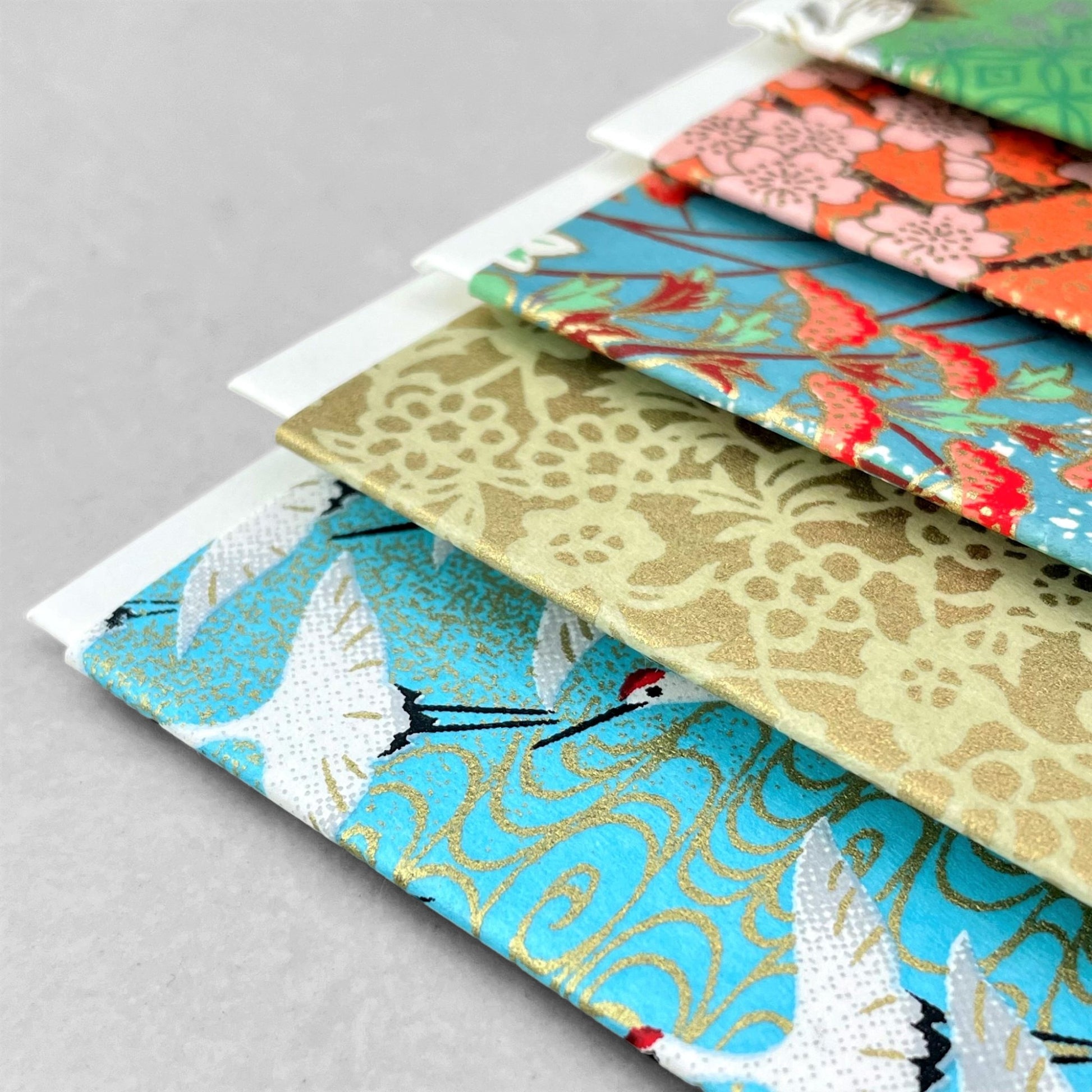 japanese silk-screen printed greetings card with a repeat diagonal pattern of white cranes on an aqua backdrop by Esmie