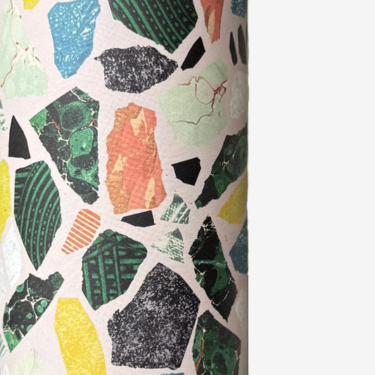 Colorful terrazzo pattern on a pale pink background. A sheet of wrapping paper