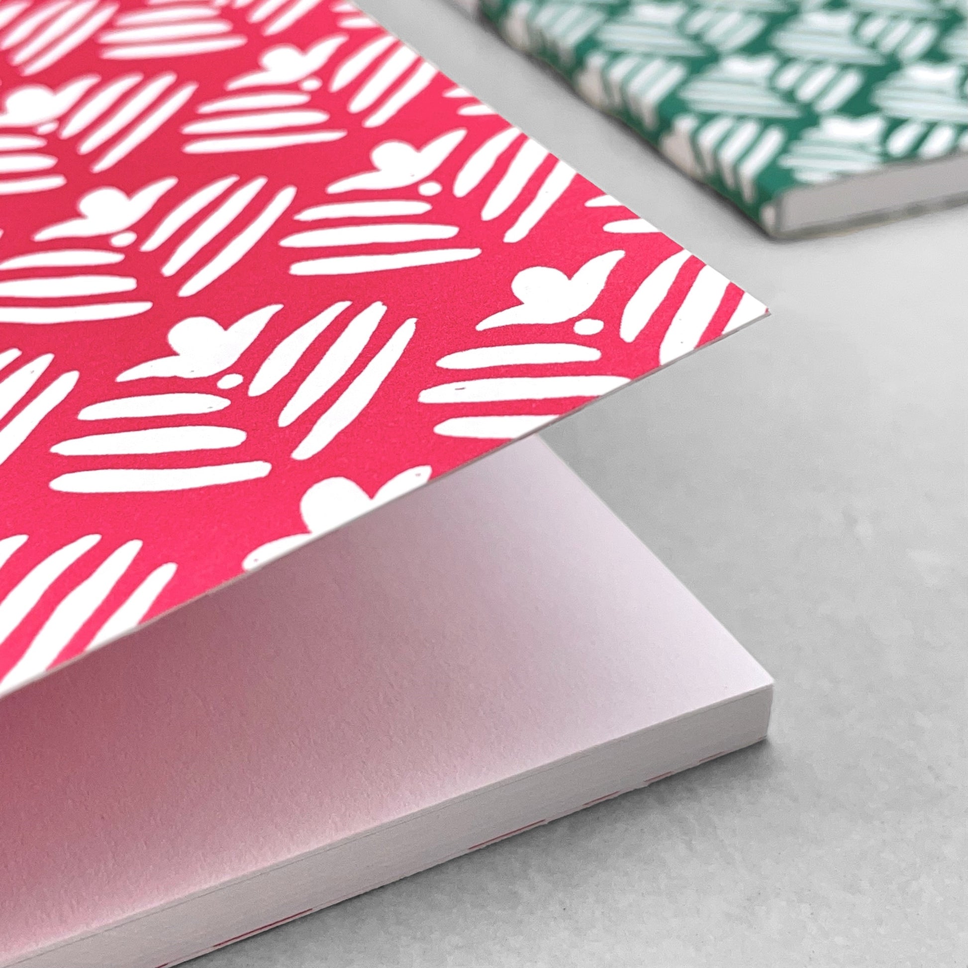 A5 notebook with magenta pink cover and repeat pattern of white flowers by Heather Evelyn
