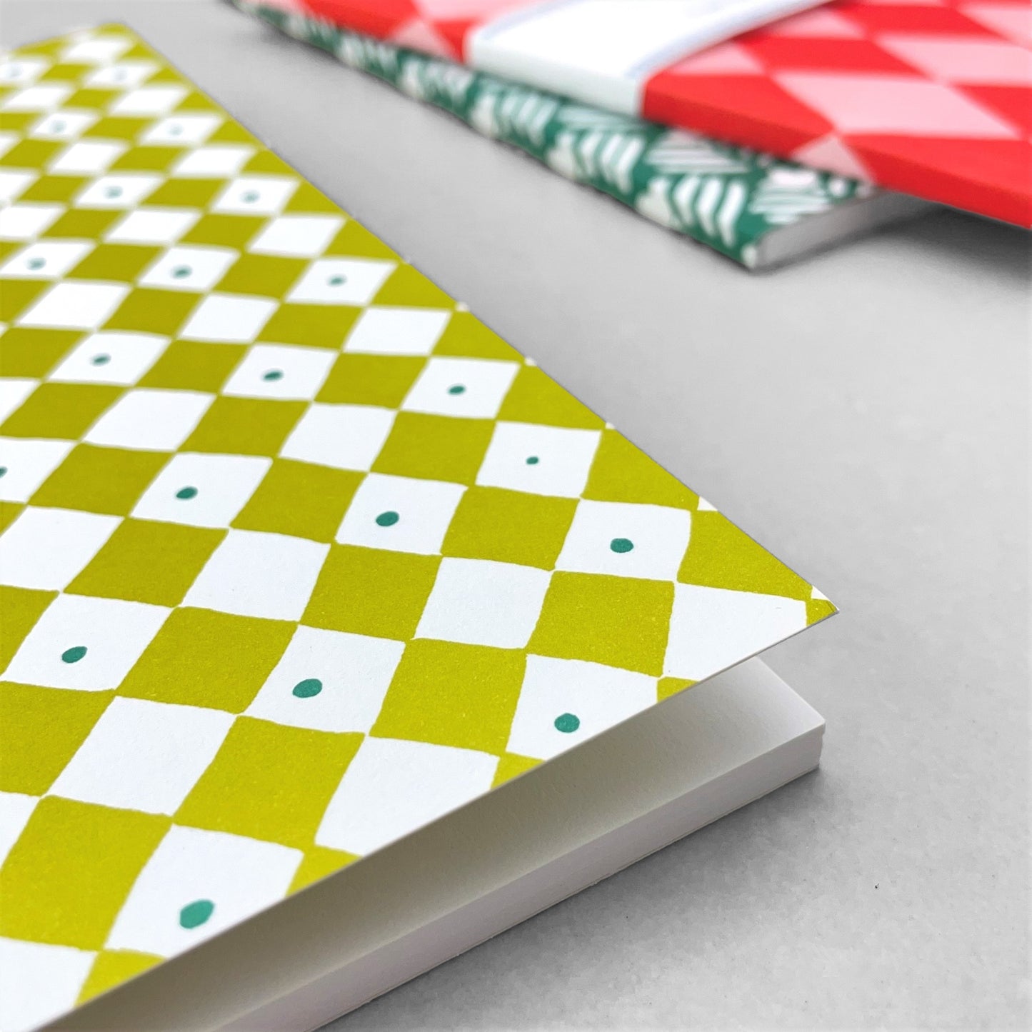 A5 notebook with a diagonal chequered pattern cover in lime green and white. by Heather Evelyn
