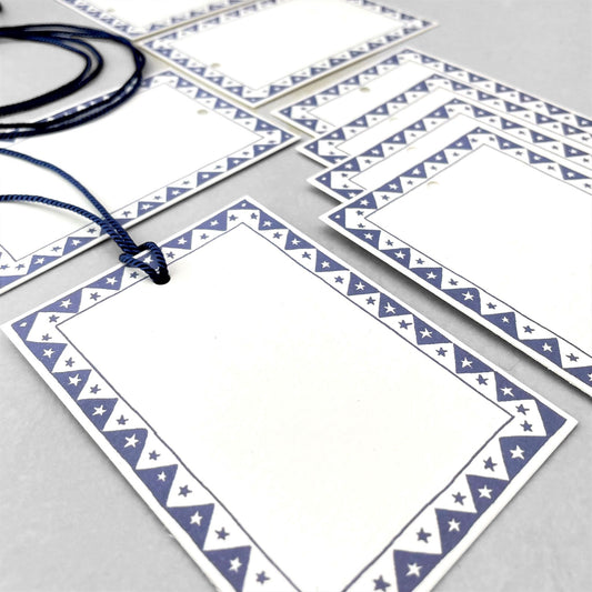 White rectangular gift tag with dark blue star pattern border and blue cord by Heather Evelyn