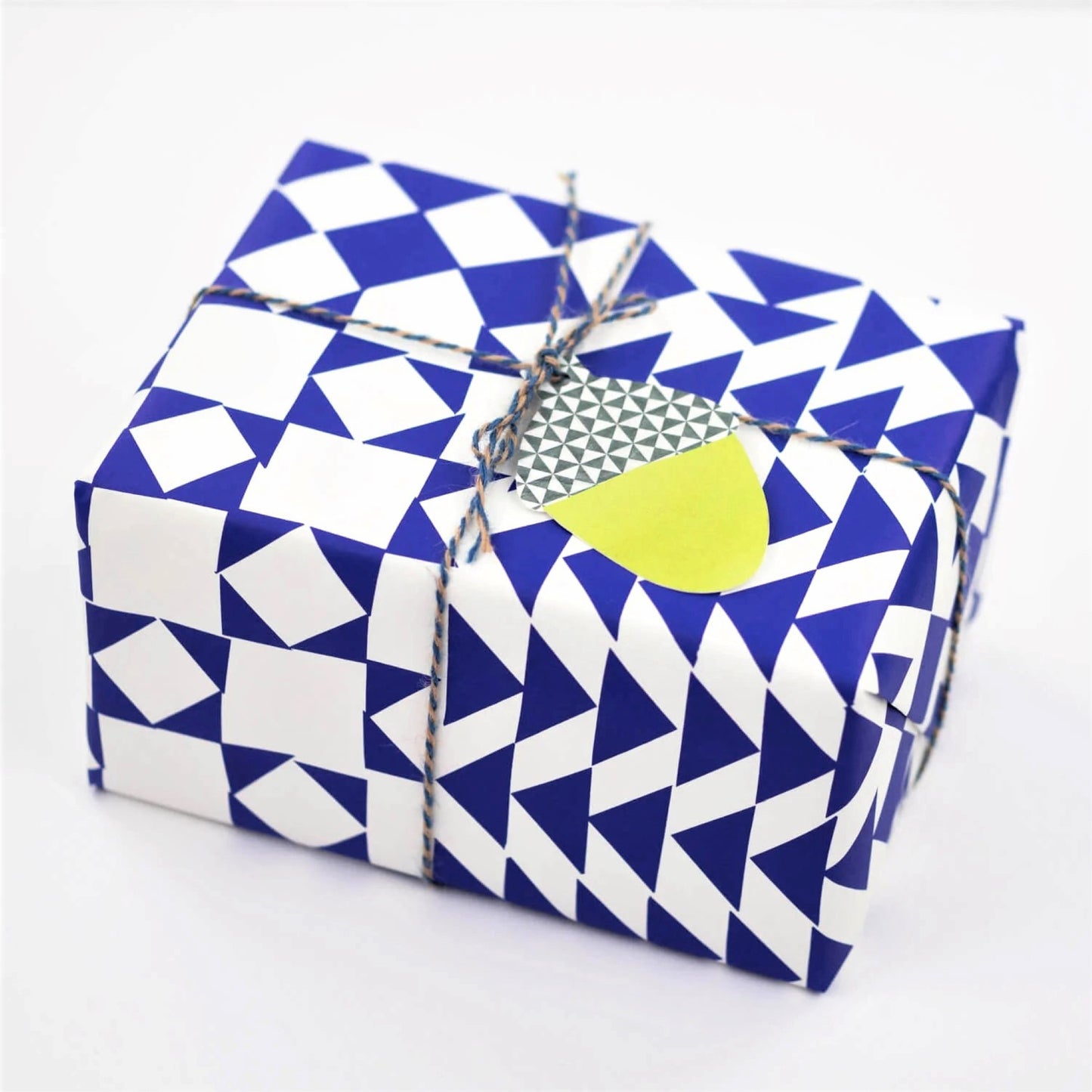 blue and white geometric wrapping paper by Hadley Paper Goods, wrapped as a present