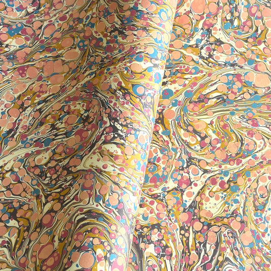 printed marbled wrapping paper by Jemma Lewis with a marbled pattern in blush pink, mustard, pale blue, brown and raspberry.