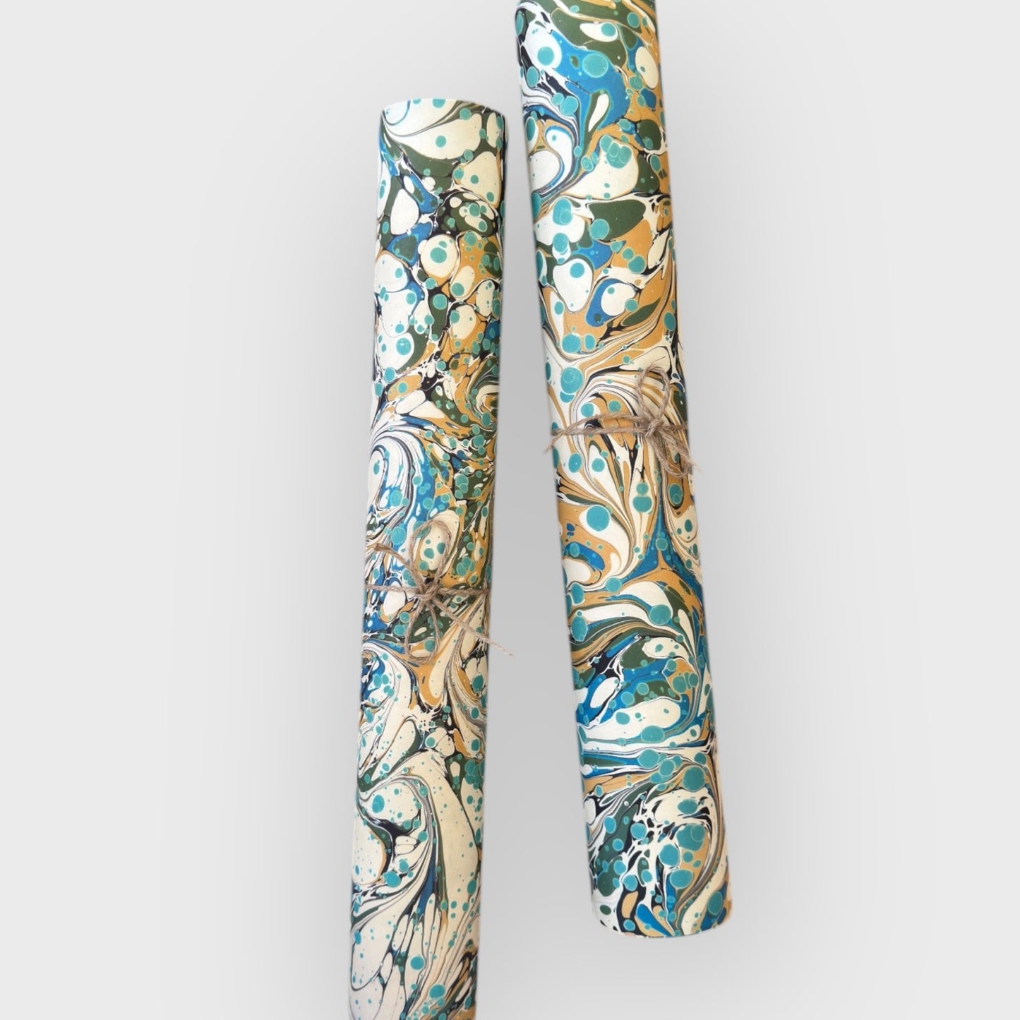 printed marbled wrapping paper with marbled pattern in aqua, blue, sand and cream. Pictured rolled