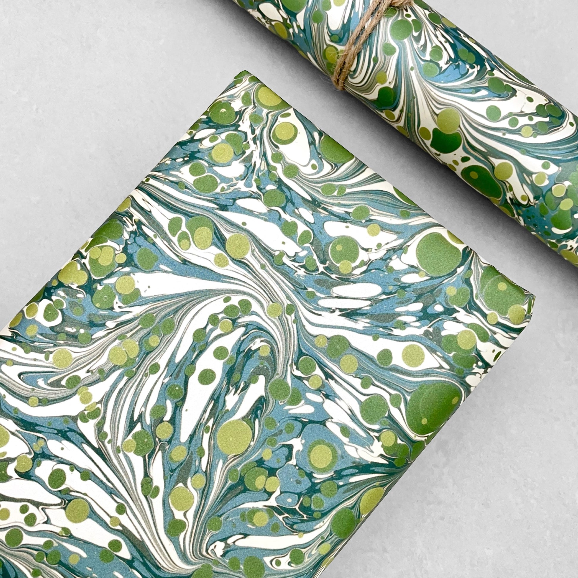 Printed marbled wrapping paper by Jemma Lewis Marbling. Marbled paper with a shimmery base paper and marbled pattern in green, lime and white