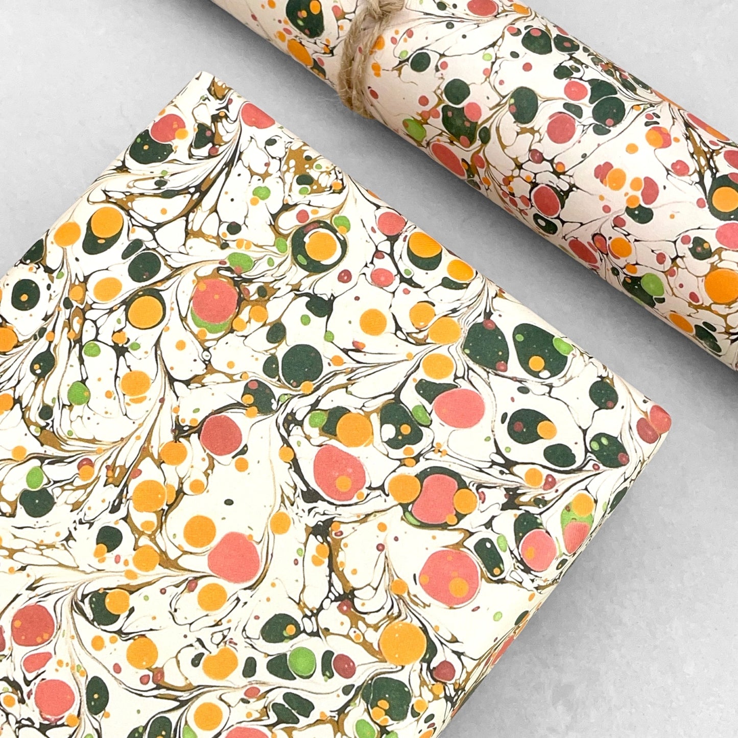 Printed marbled wrapping paper by Jemma Lewis Marbling. Marbled paper in bright yellow, pink and green on white backdrop.