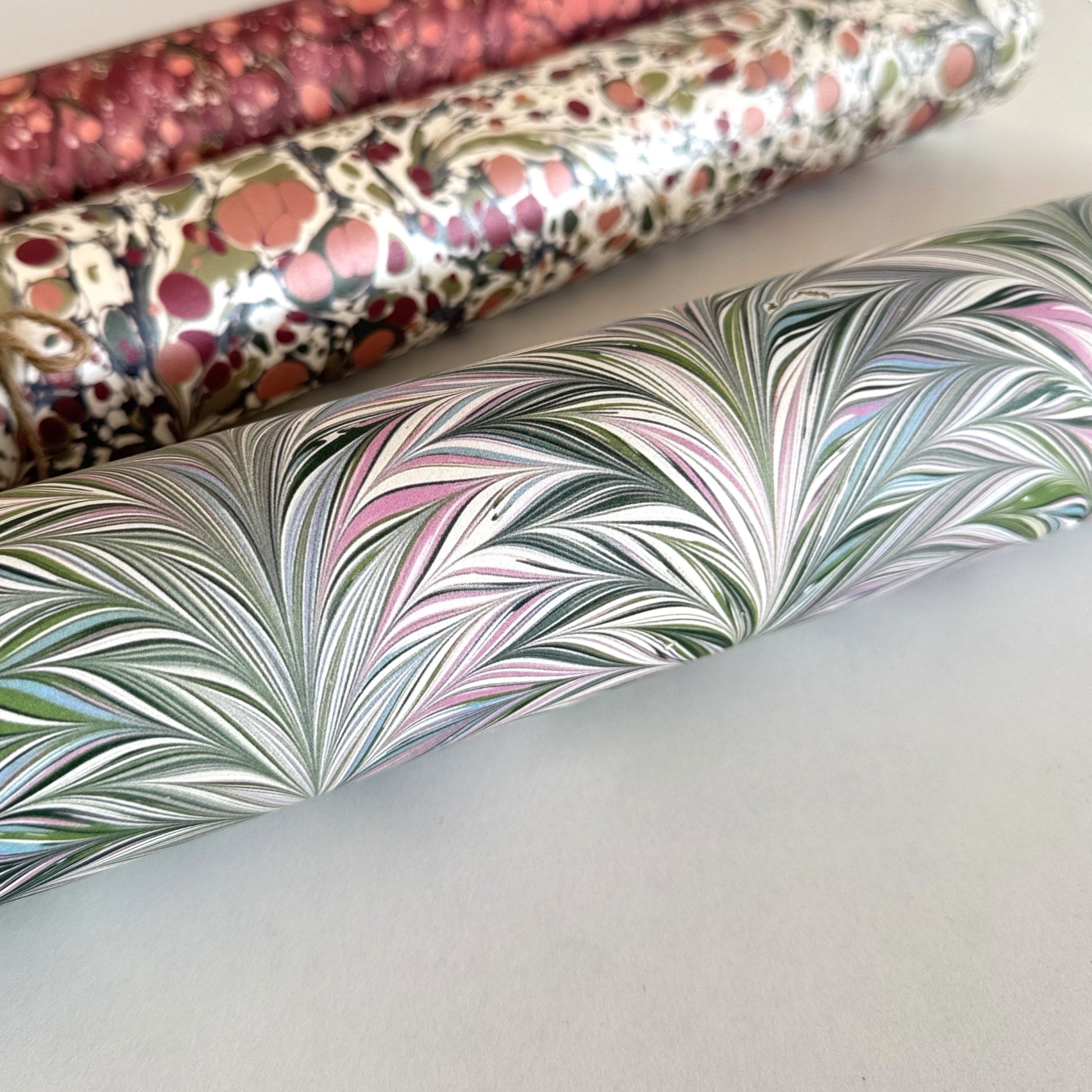 printed marbled design wrapping paper by Jemma Lewis, a feathered marble in green and lilac. close up