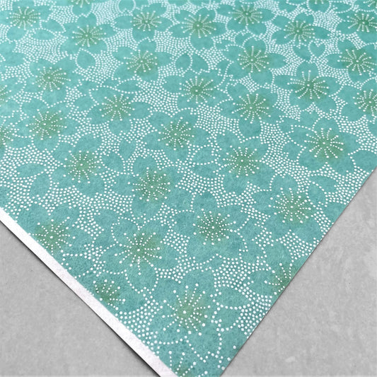 japanese silk-screen paper, chiyogami, with a cherry blossom flower repeat pattern in turquoise and white