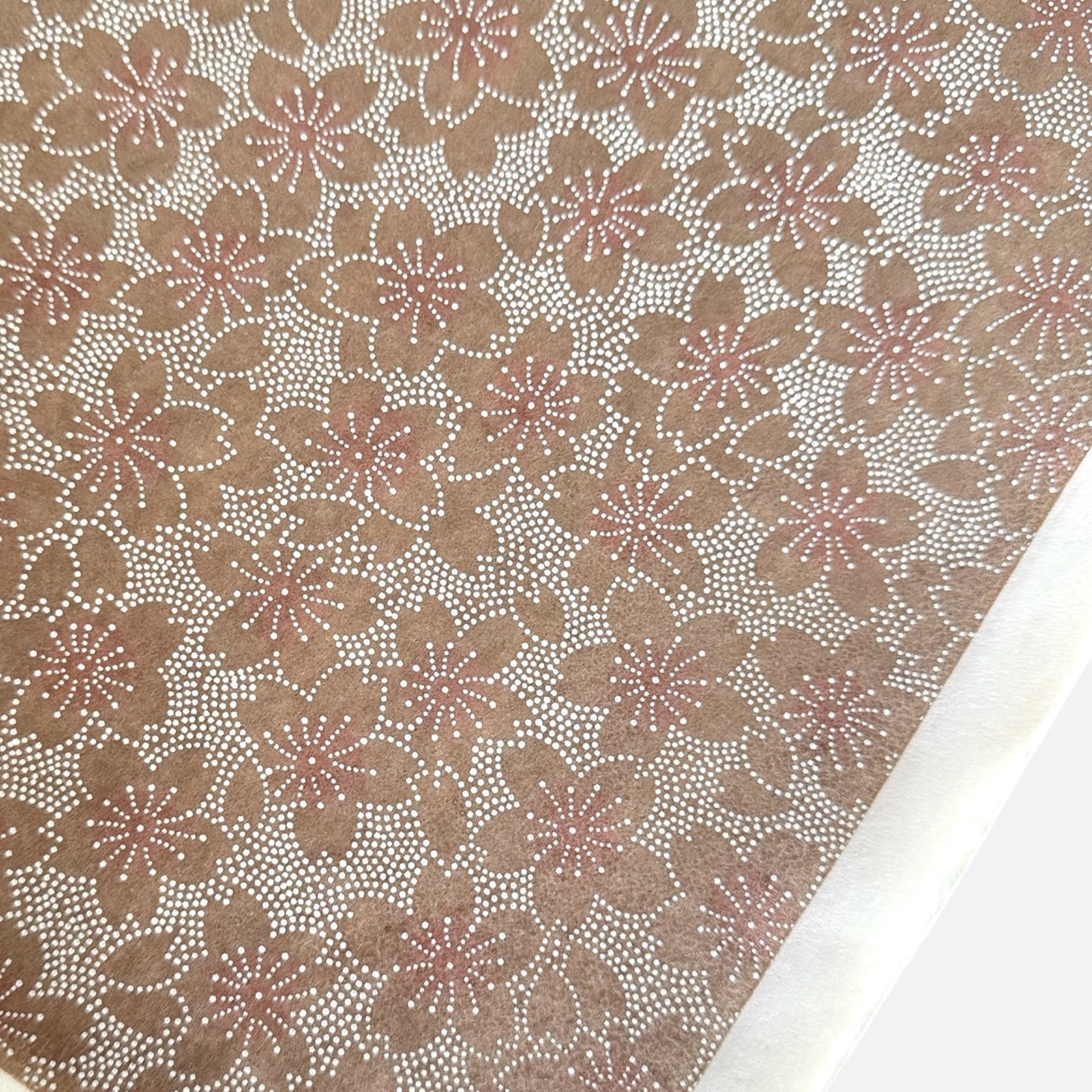 Japanese silkscreen chiyogami paper with a repeat pattern of cherry blossom flowers in taupe and white