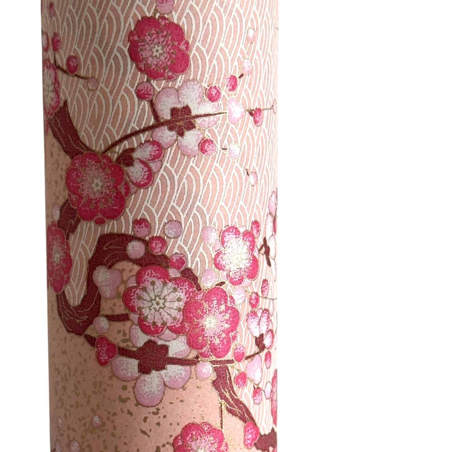 Diagonal branches of pink plum (ume) blossom on a light pink background with gold accents. Japanese chiyogami paper
