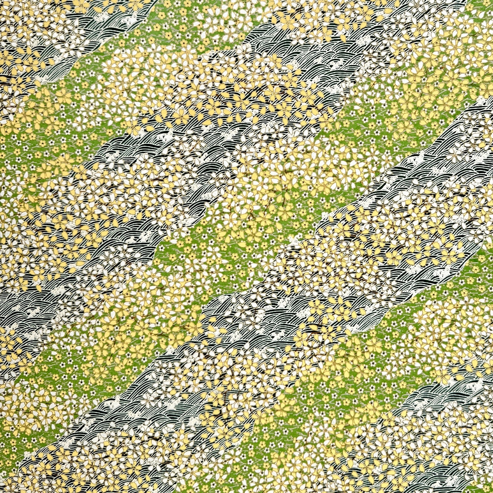 Japanese silkscreen chiyogami paper with a pattern of dark green rivers and grass green banks with an abundance of little flowers in white and yellow