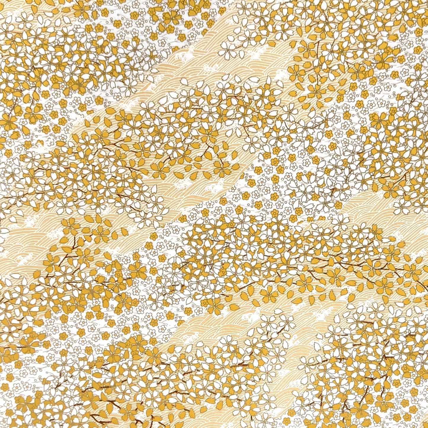 a sheet of Japanese chiyogami yuzen paper with a delicate pattern of little sakura cherry blossom in amber yellow and white