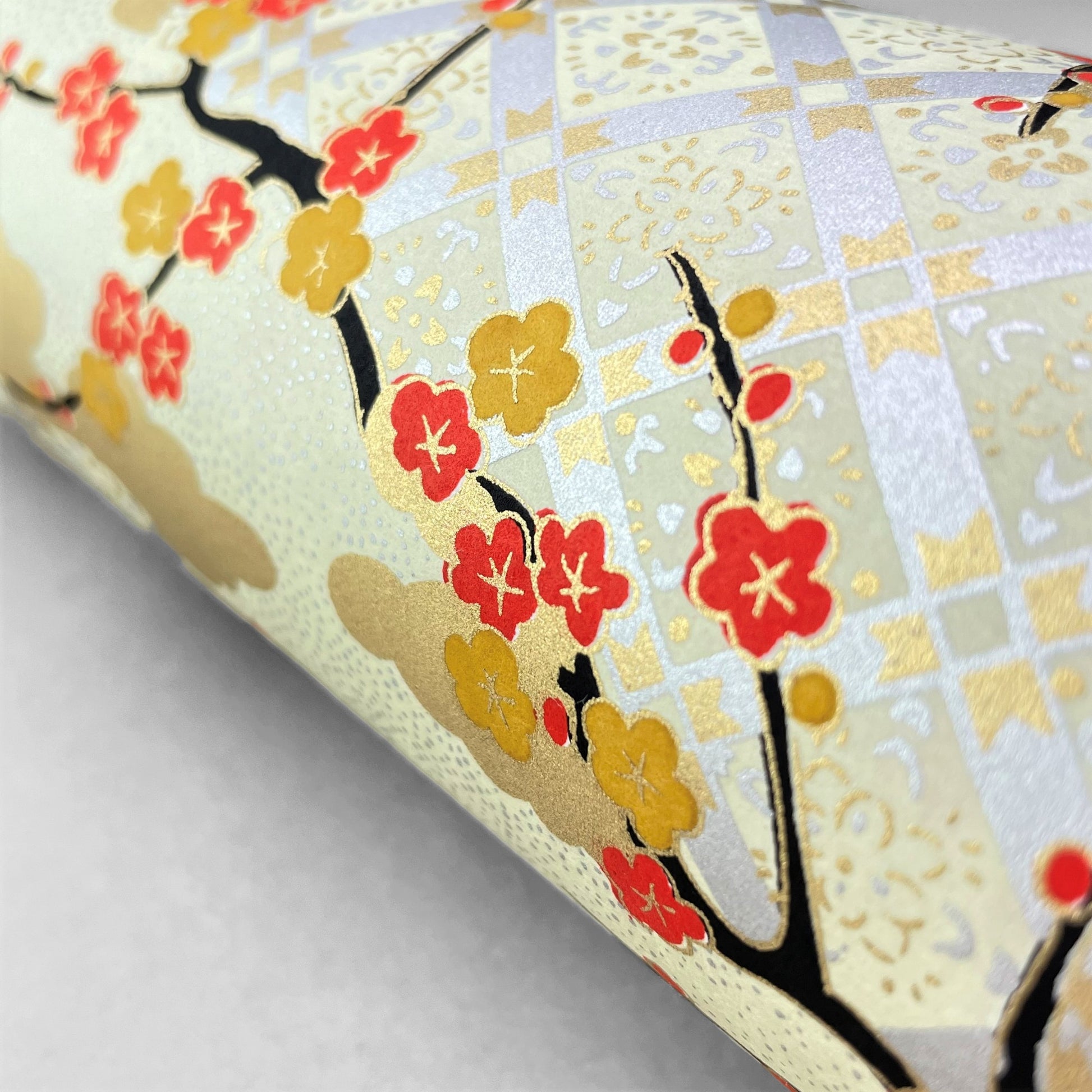 japanese silk-screen handmade paper, chiyogami, showing branches of red cherry blossom and gold clouds on a backdrop of silver, cream and gold