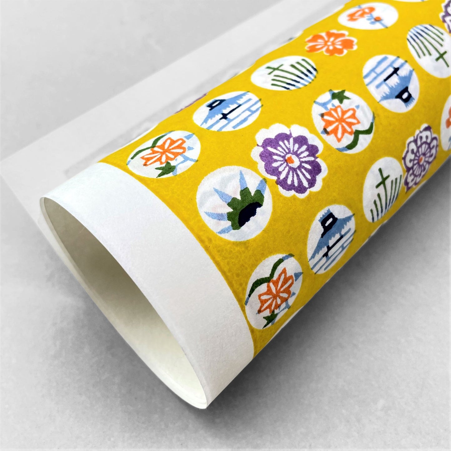 japanese silk-screen handmade paper showing circles of traditional motifs on yellow backdrop
