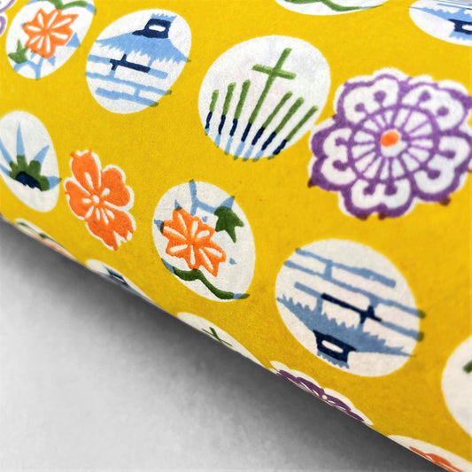 japanese silk-screen handmade paper showing circles of traditional motifs on yellow backdrop