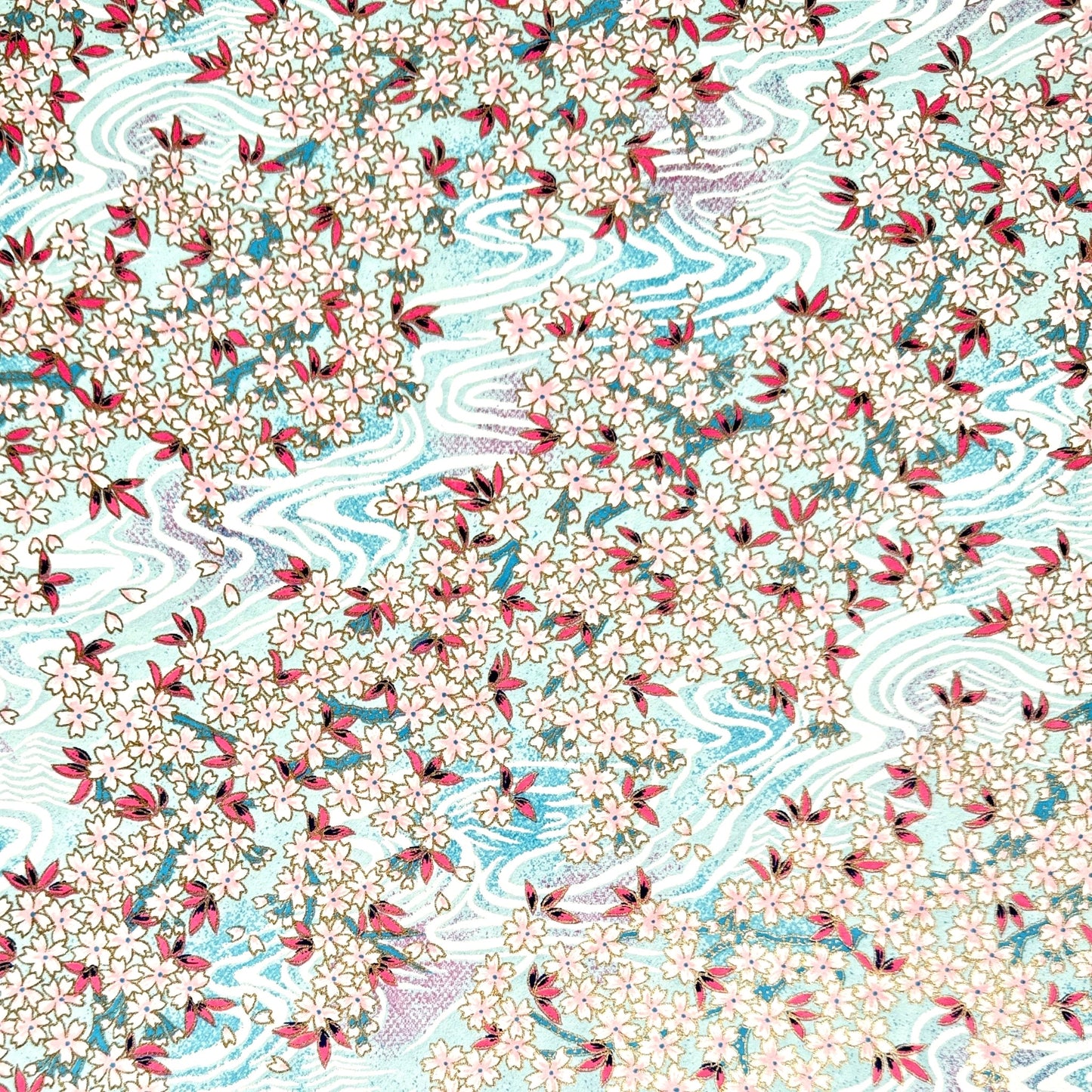 Japanese silkscreen chiyogami paper with an abundance of pale pink cherry blossom with a pale blue backdrop of meandering water, finished with metallic gold ink.