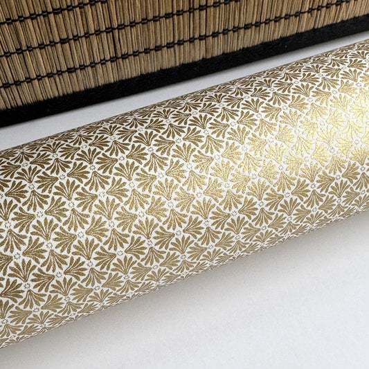 a sheet of Japanese silkscreen printed chiyogami yuzen paper with a micro gold geometric pattern on white backdrop. Close up