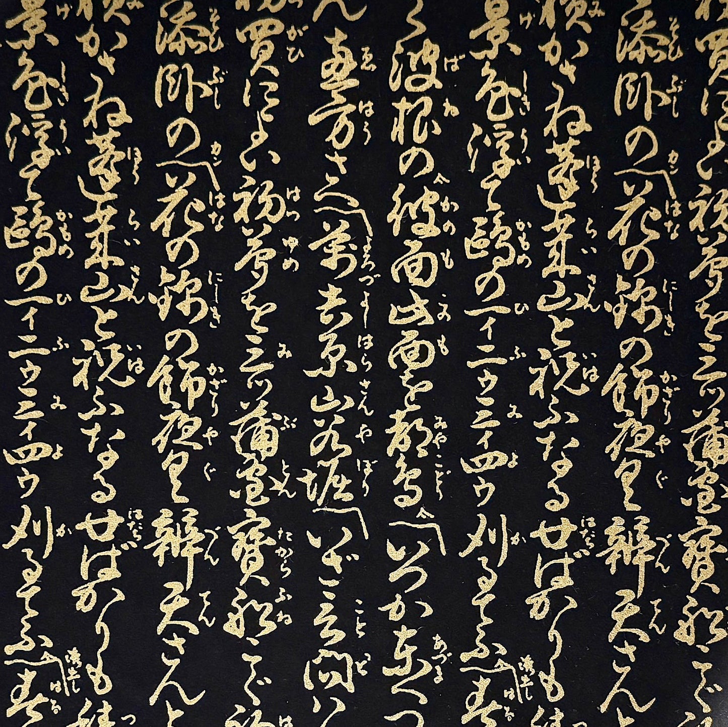 a sheet of Japanese chiyogami paper with gold Japanese kanji text on black background