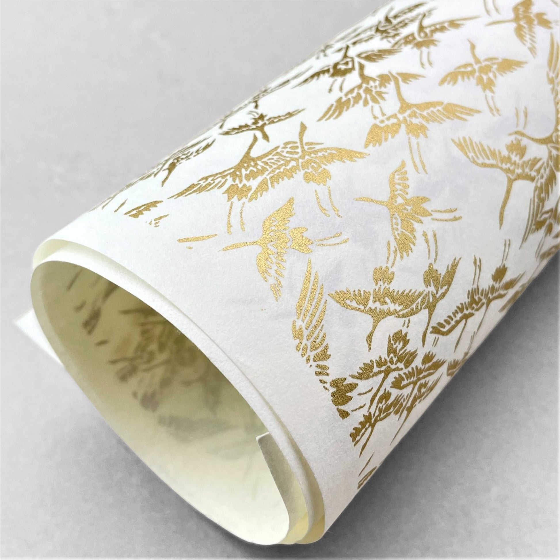 japanese silk-screen handmade paper showing gold cranes in flight on ivory backdrop