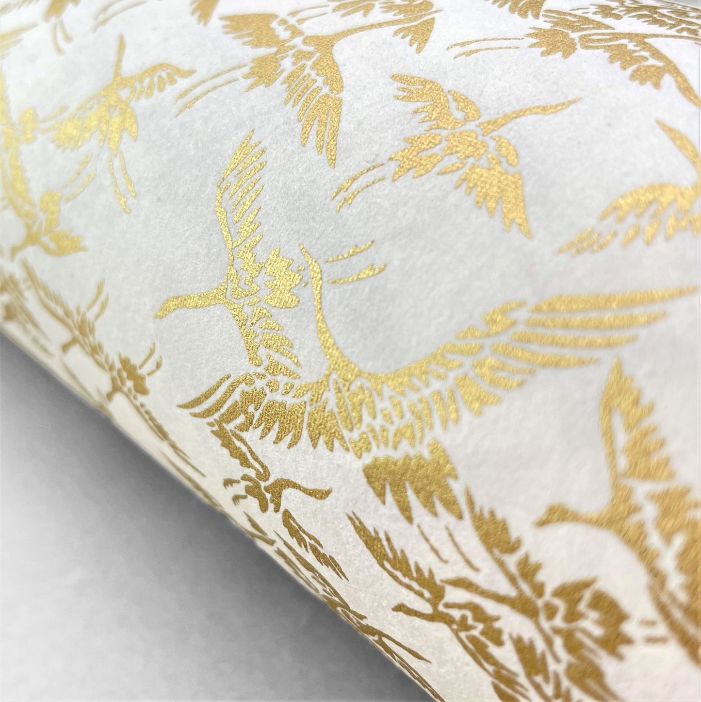 japanese silk-screen handmade paper showing gold cranes in flight on ivory backdrop