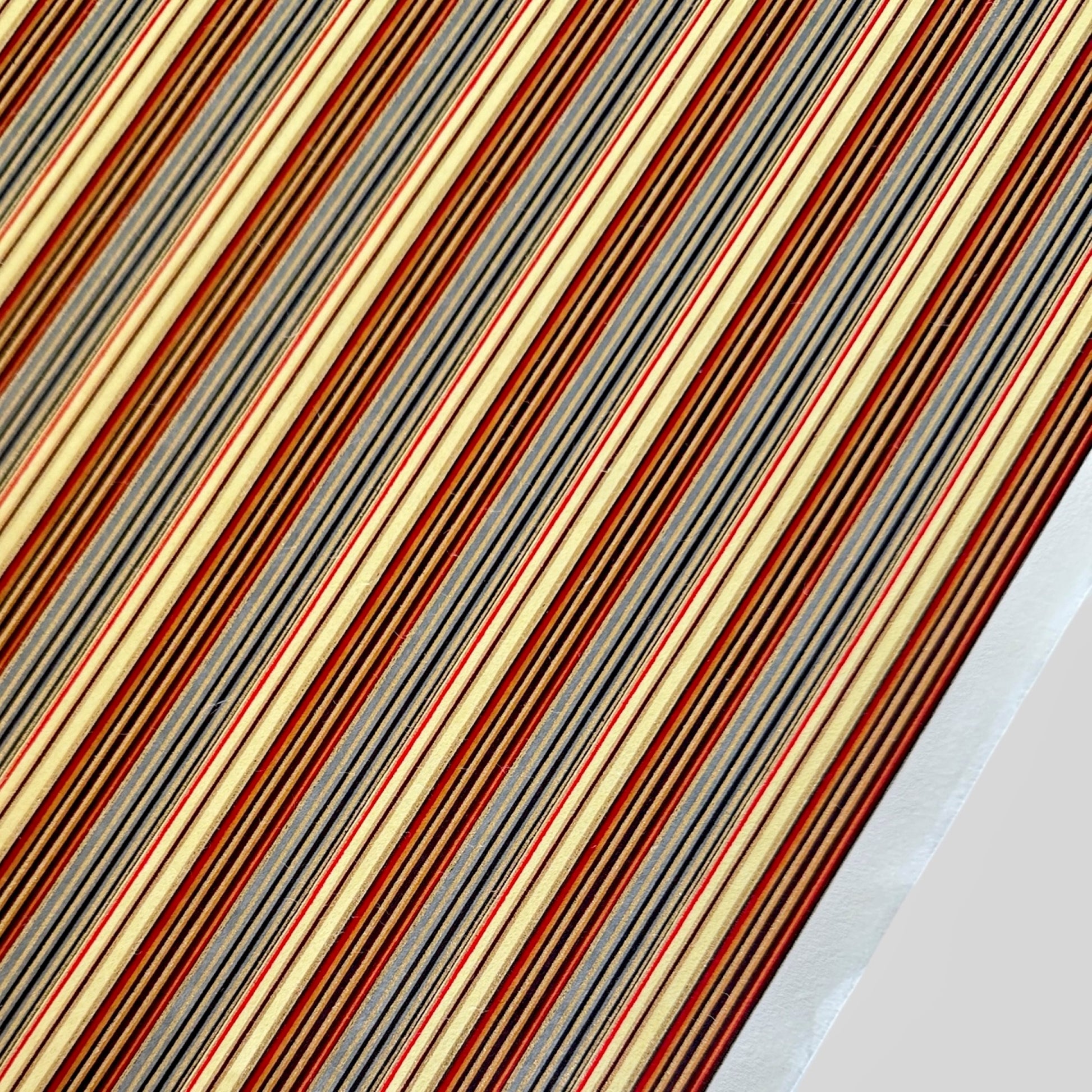 Japanese silkscreen chiyogami paper with a classic narrow stripe pattern in earthy tones of brown, grey, cream, black and gold.