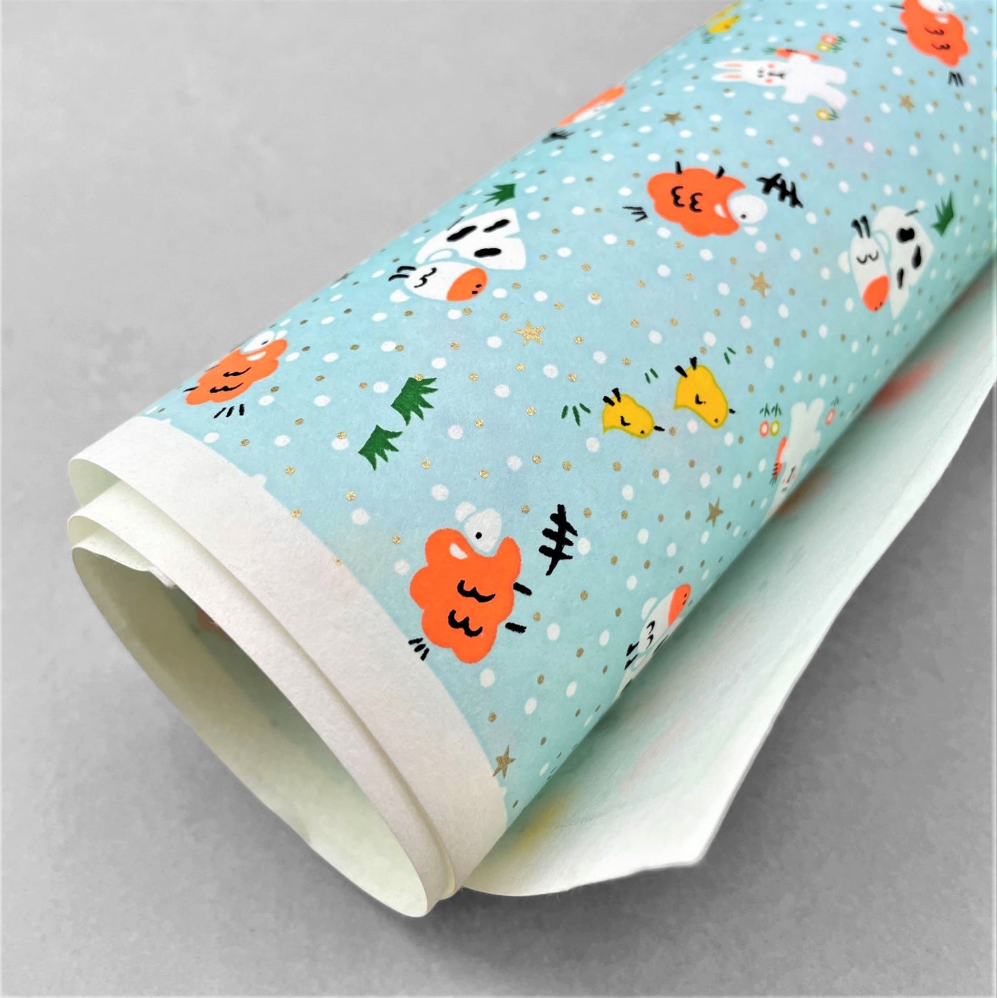 japanese silk-screen handmade paper showing spring animals motifs on a light blue backdrop
