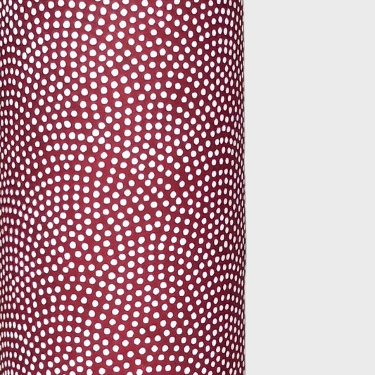 a sheet of Japanese chiyogami paper with an aubergine background and a small repeat pattern of tiny white dots in an arch shape