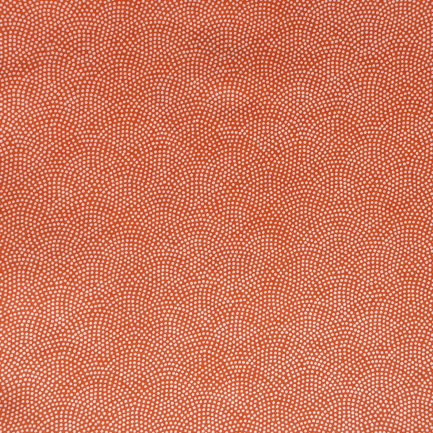 a sheet of chiyogami with a coral orange background and an small dotted arch pattern