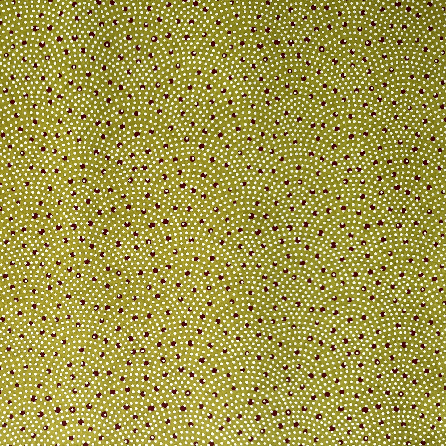 a sheet of Japanese chiyogami paper with an olive backdrop and a white dotted repeat arch pattern with red dots