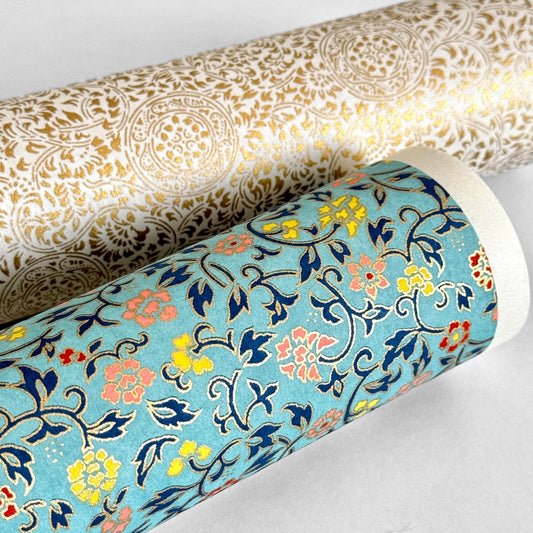 Japanese silkscreen chiyogami paper with a dainty floral pattern in navy, yellow and coral on a teal backdrop. Finished with gold metallic ink. Rolled paper