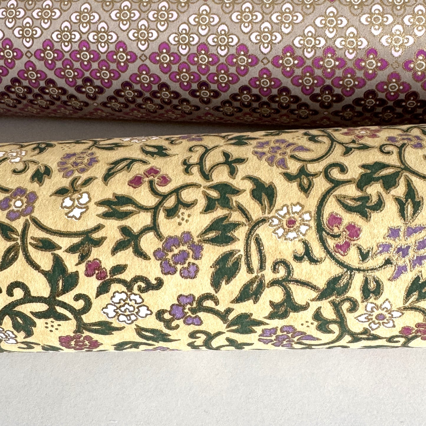Japanese chiyogami silkscreen paper with a dainty floral pattern on a creamy backdrop and finished with gold metallic ink. Close-up