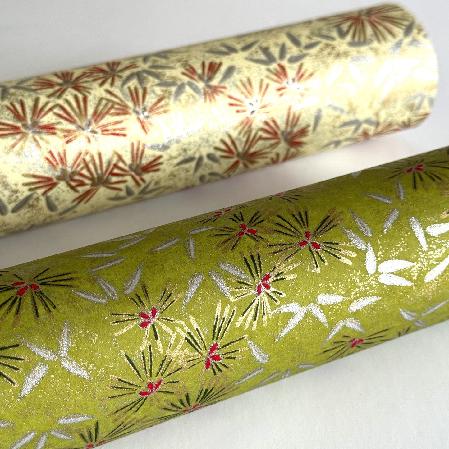 Pattern of scattered pine needles (matsuba) in gold and silver on an olive backdrop. Japanese chiyogami paper. Rolled