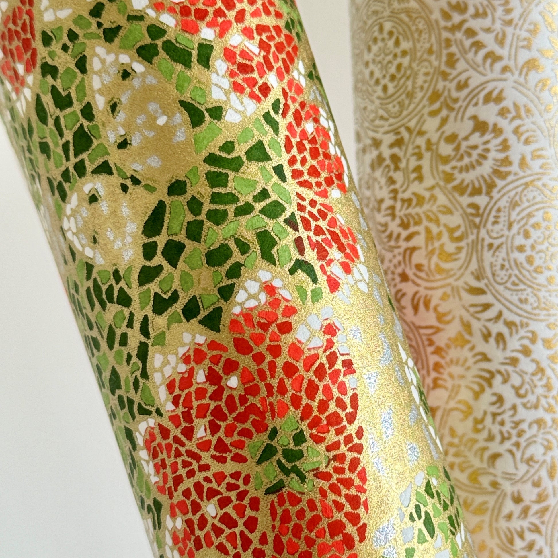 Japanese silkscreen chiyogami paper with a mosaic pattern of scarlet chrysanthemums on gold with green foliage. Close up