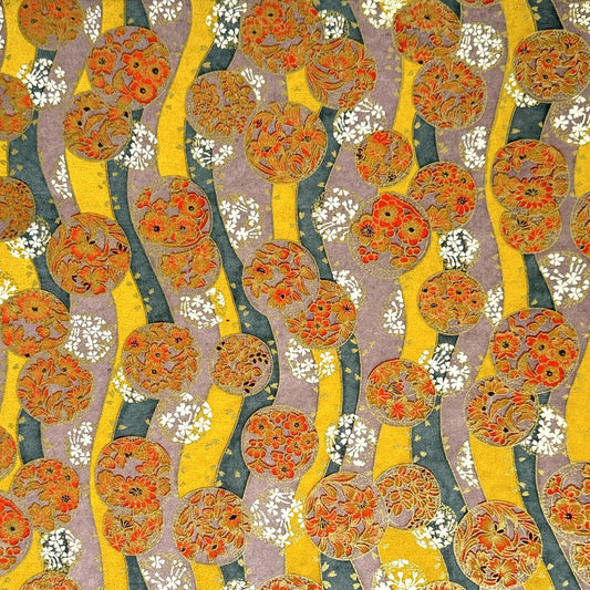 Japanese silkscreen chiyogami paper with a traditional botanical circle motif in tones of mustard, inky blue, lilac and gold.