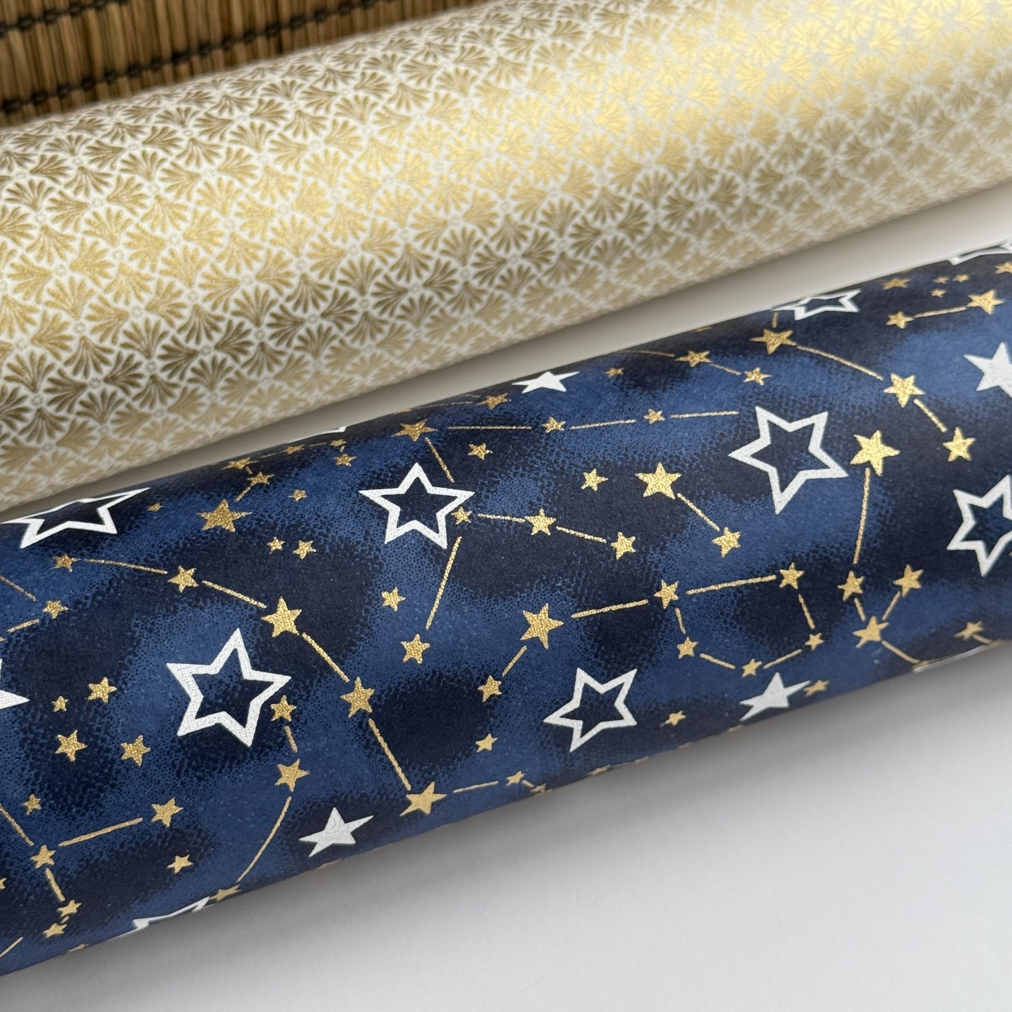 a sheet of Japanese chiyogami yuzen paper with a pattern of white and gold stars on a midnight blue background