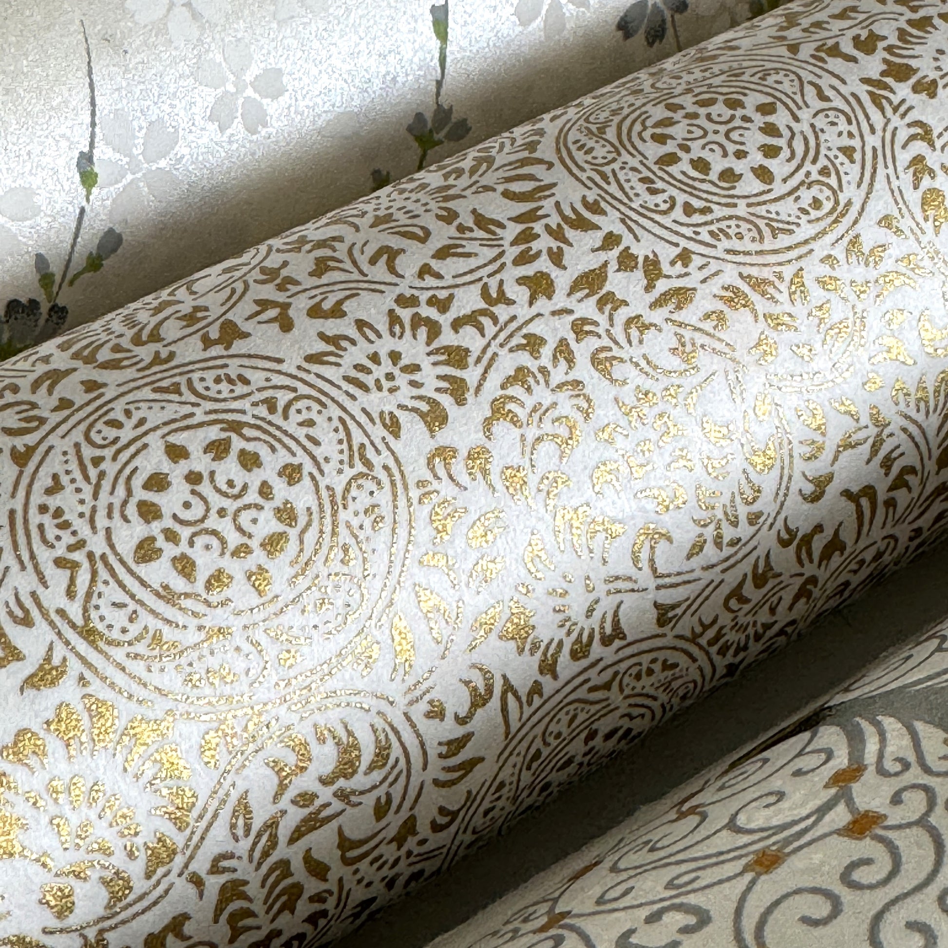 Japanese silkscreen chiyogami paper with an intricate floral pattern in gold on ivory white. Close-up