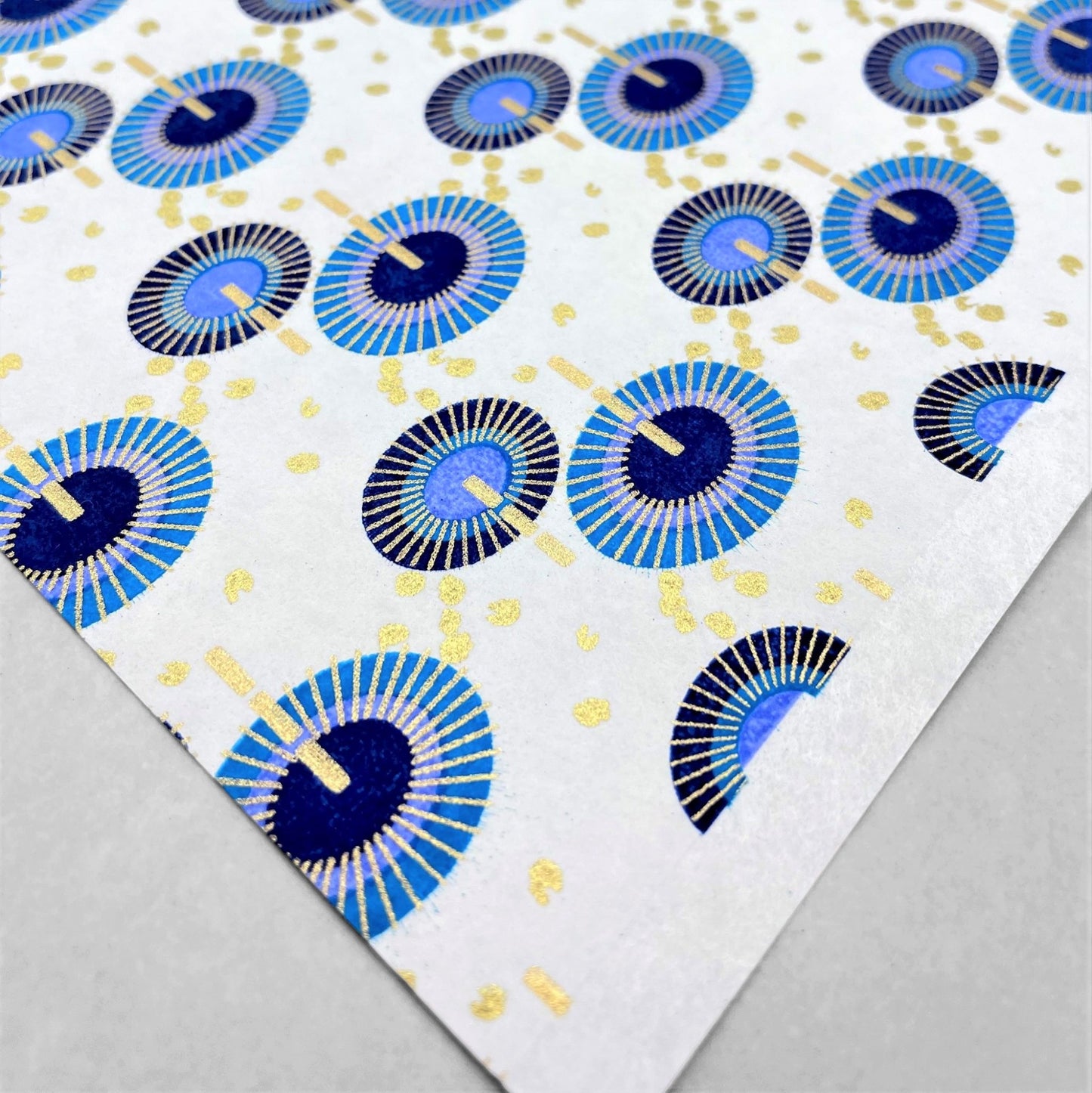 japanese silk-screen handmade paper showing a repeat pattern of blue umbrellas with gold highlights